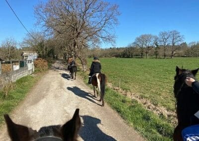 Grupo de jinetes en fila por una pista rural durante la ruta a caballo cerca de Gijón